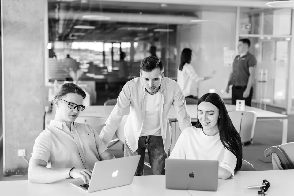 Time de uma empresa de software reunido em volta de notebooks